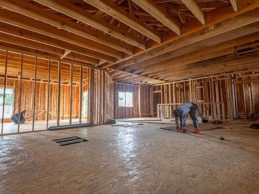 Framed walls and floor joists inside a home under structural work